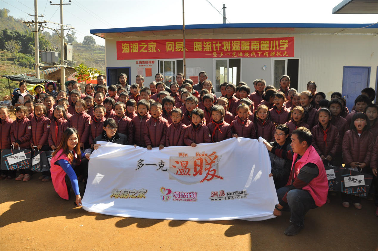 2014年11月20日，&ldquo;多一克溫暖&rdquo;公益團隊來到8.3大地震的重災區(qū)&mdash;&mdash;云南省昭通市魯?shù)榭h的南筐小學。越過崎嶇山路，將一批又一批暖心羽絨服送到了師生們的手中，也將社會的關懷和愛意傳遞給了這些可愛的人。