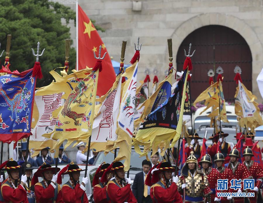 7月3日，韓國(guó)總統(tǒng)樸槿惠在青瓦臺(tái)總統(tǒng)府舉行隆重儀式，歡迎中國(guó)國(guó)家主席習(xí)近平對(duì)韓國(guó)進(jìn)行國(guó)事訪問。這是習(xí)近平的車隊(duì)在身著民族服裝的韓國(guó)禮儀隊(duì)伍引導(dǎo)下駛?cè)肭嗤吲_(tái)。新華社記者丁林?jǐn)z  