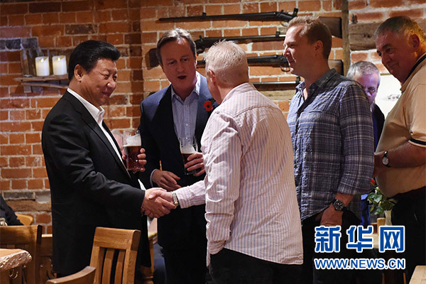 這是習(xí)近平與卡梅倫飲啤酒，并同當(dāng)?shù)孛癖娊徽劇Ｐ氯A社記者 饒愛(ài)民 攝